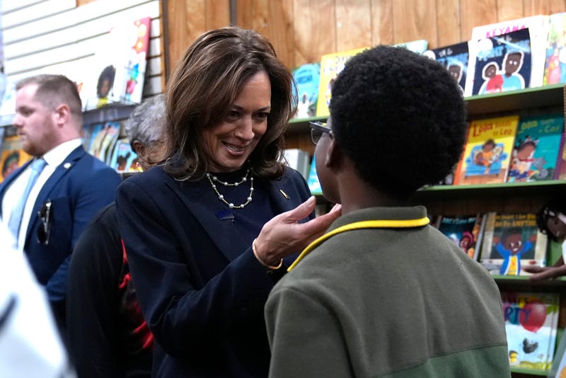 Democratic presidential nominee Vice President Kamala Harris, left, greets a young man at Hakim's Bookstore and Gift Shop during a campaign stop, Sunday, Oct. 27, 2024, in Philadelphia.