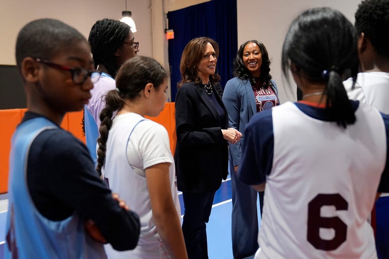 Democratic presidential nominee Vice President Kamala Harris, center, speaks with young basketball players alongside coach Randyll Butler, right, before a community rally at the Alan Horwitz "Sixth Man" Center, Sunday, Oct. 27, 2024, in Philadelphia.