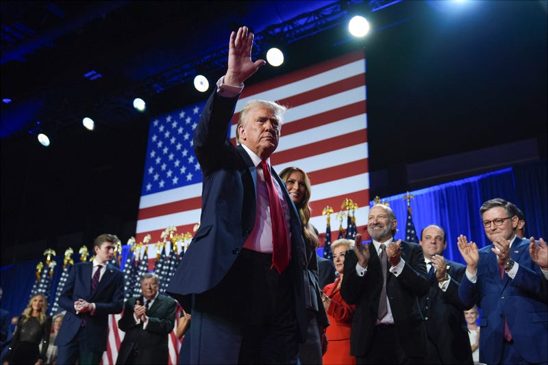 Former President Donald Trump waves as he walks with former first lady Melania Trump at an election night watch party