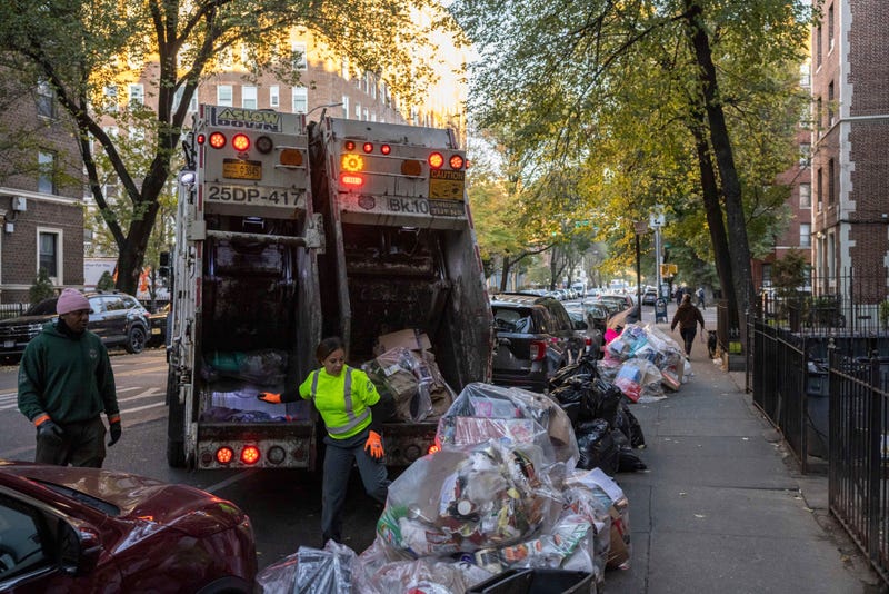 Sanitation workers collect trash, Saturday, Nov. 16, 2024, in the Brooklyn borough of New York