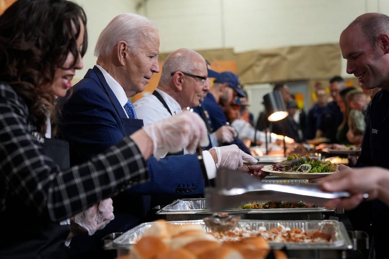 President Joe Biden, from second left, and chef Robert Irvine serve food at a Friendsgiving event with service members and their families in the Staten Island borough of New York, Monday, Nov. 25 2024