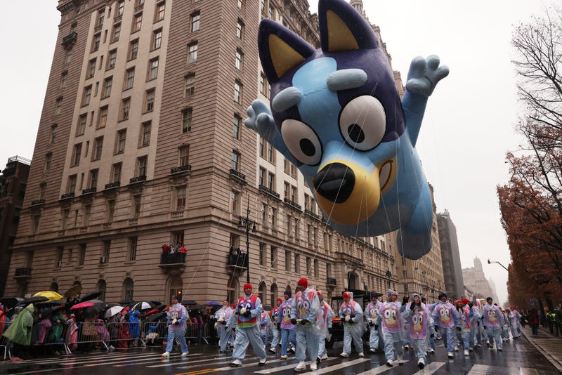 Handlers pull the Bluey balloon down Central Park West