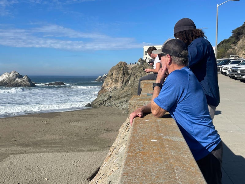 People watch the waves come