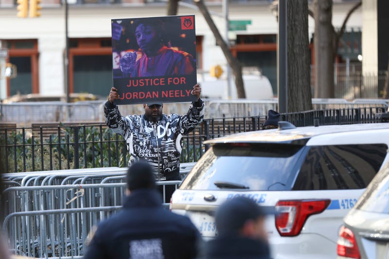 A protester holds a "Justice for Jordan Neely" sign before Daniel Penny arrives at court, Friday, Dec. 6, 2024, in New York