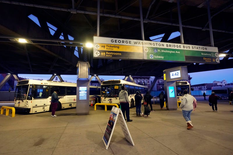 Commuters wait for buses at the George Washington Bridge Bus Station in New York, Friday, Dec. 6, 2024, where the gunman fleeing Wednesday's shooting of UnitedHealthcare CEO Brian Thompson took a taxi to, according to surveillance video