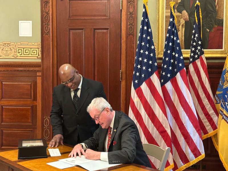 New Jersey Gov. Phil Murphy signs a pardon for Abdur Azam, left, on Monday, Dec. 16, 2024, at his statehouse office in Trenton.