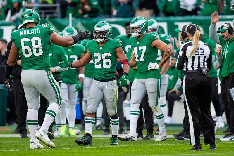 Philadelphia Eagles running back Saquon Barkley is congratulated by offensive tackle Jordan Mailata and teammates after running for a long gain to put him at over 2,000 yards for the season during the second half of an NFL football game against the Dallas Cowboys on Sunday.