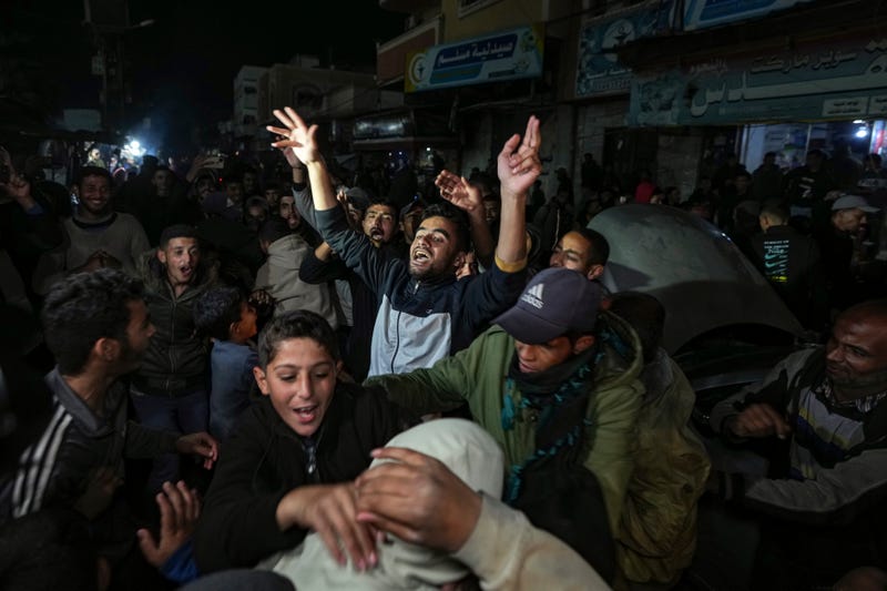 Palestinians celebrate the announcement of a ceasefire deal between Hamas and Israel in Deir al-Balah, central Gaza Strip, Wednesday, Jan. 15, 2025