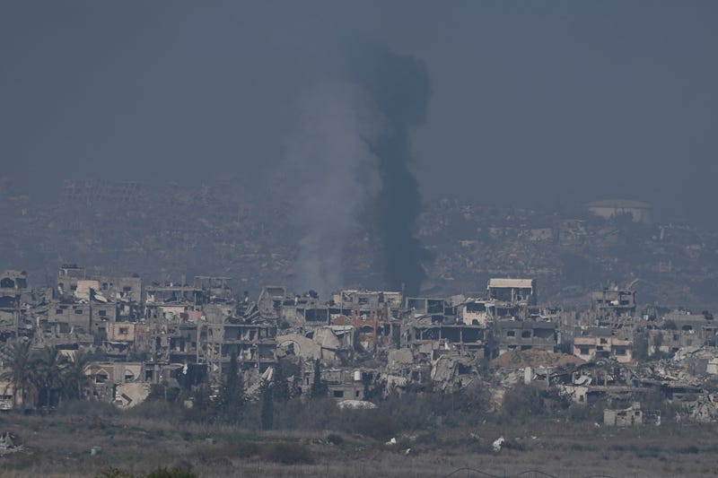 Smoke rises behind destroyed buildings by Israeli bombardments as seen inside the Gaza Strip from southern Israel, Thursday, Jan. 16, 2025