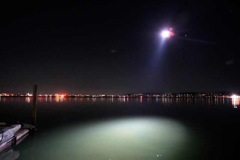 A helicopter uses a spotlight on the Potomac River near Ronald Reagan Washington National Airport, Jan. 30, 2025, in Arlington, Va.