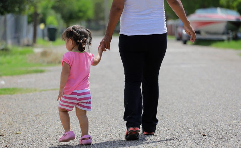 In this Sept. 16, 2015, photo, a woman in Sullivan City, Texas, who said she entered the country illegally, walks with her daughter who was born in the United States but was denied a birth certificate.