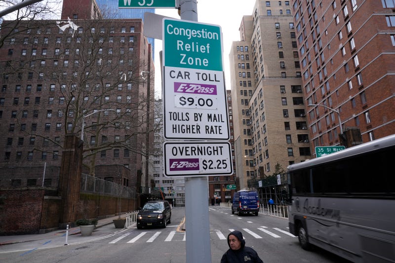 Signs advising drivers of congestion pricing tolls are displayed near the exit of the Lincoln Tunnel in New York, Wednesday, Feb. 19, 2025