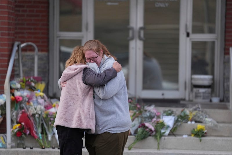 Leah Fauth gets a hug after leaving flowers in front of the West York Police Department after a police officer was killed responding to a shooting at UPMC Memorial Hospital in York, Pa., on Saturday.