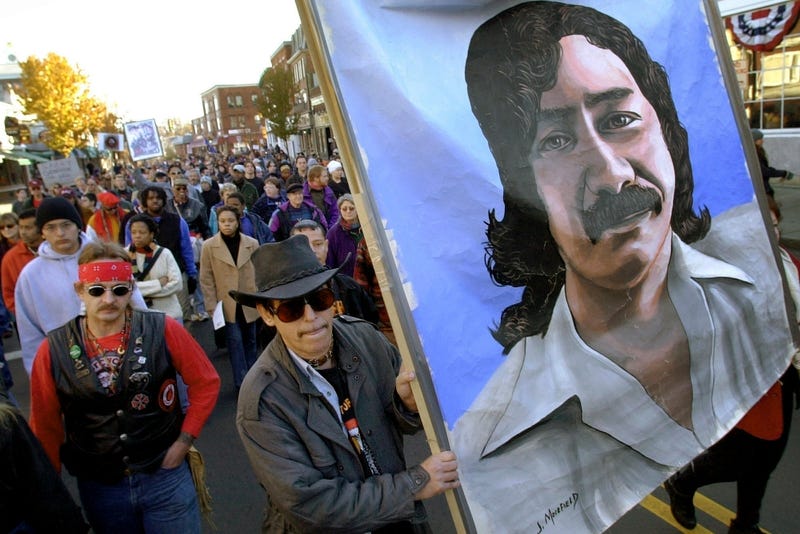 Marchers carry a large painting of jailed Native American activist Leonard Peltier during a march for the National Day of Mourning in Plymouth, Mass., on Nov. 22, 2001.