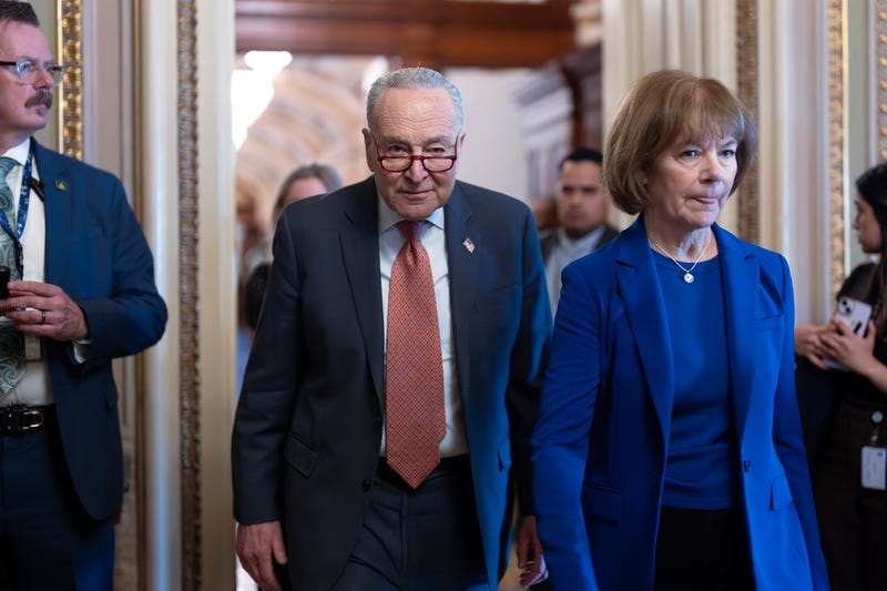 Senate Minority Leader Chuck Schumer, D-N.Y., left, walks with Sen. Tina Smith, D-Minn., as Senate Democrats gather behind closed doors to mount a last-ditch protest over a Republican-led spending bill that already passed the House, at the Capitol in Washington.