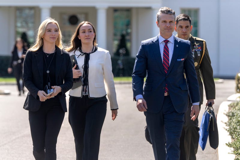 Defense Secretary Pete Hegseth, second from right, walks outside the Oval Office at the White House, Friday, March 21, 2025, in Washington.