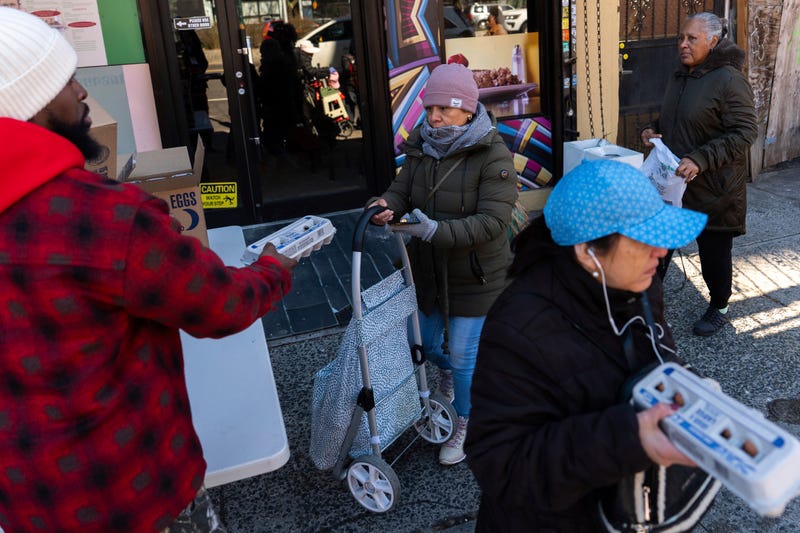 Abou Sow hands out cartons of eggs to people waiting in line to receive free eggs from FarmerJawn Agriculture, Friday, March 21, 2025, in the Harlem neighborhood of New York.