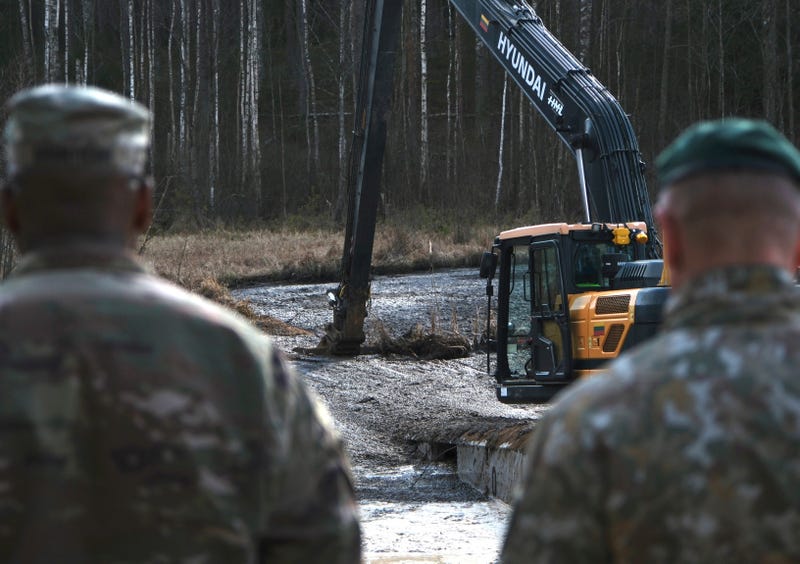 In this image provided by the U.S. Army, U.S. Army soldiers from the 1st Armored Brigade Combat Team, 3rd Infantry Division, along with Lithuanian Army and emergency services personnel, discuss their plan to recover four U.S. soldiers in a U.S. Army M88 Hercules submerged under several meters of water in a swamp near a training area near Pabadre, Lithuania, Thursday, March 27, 2025.
