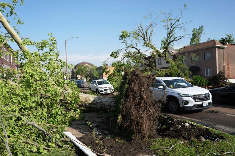 Drivers navigate around debris in the roadway after a severe storm moved through Friday, May 16, 2025, in St. Louis.