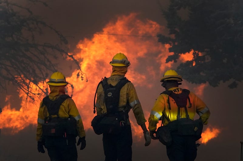 FILE - Members of a Los Angeles County Fire crew make a stand to protect a home from the advancing Bobcat Fire along Cima Mesa Rd. Friday, Sept. 18, 2020, in Juniper Hills, Calif. 