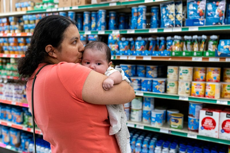 FILE - Yury Navas, 29, of Laurel, Md., kisses her two-month-old baby Jose Ismael Gálvez, at Superbest International Market in Laurel, Md., May 23, 2022, while looking for formula.
