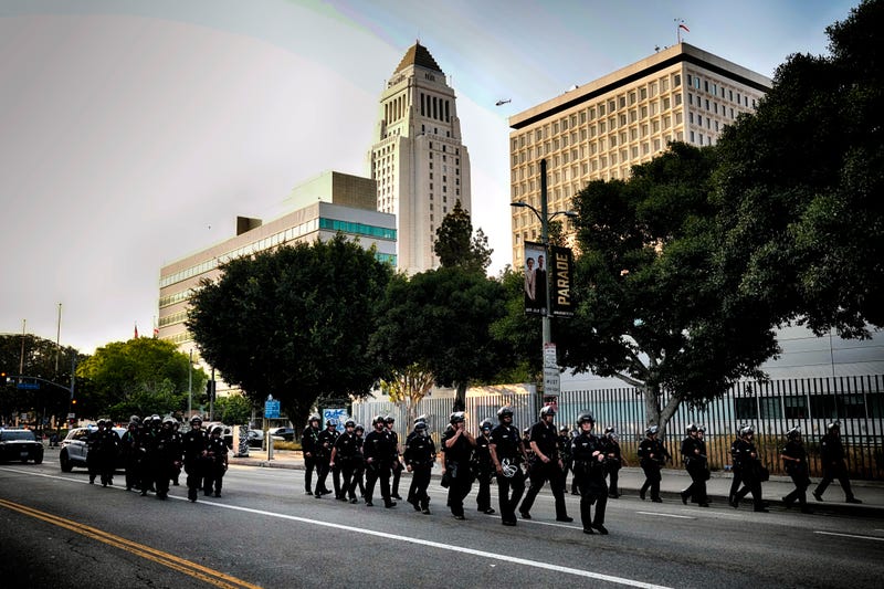 A Los Angeles police officers clear a street near Los Angeles City Hall in downtown Los Angeles on Monday, June 9, 2025.