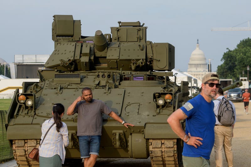 People pass by and take photos with a tank, parked on the National Mall, during preparations for an upcoming military parade commemorating the Army's 250th anniversary and coinciding with President Donald Trump's 79th birthday, Thursday, June 12, 2025, in Washington.