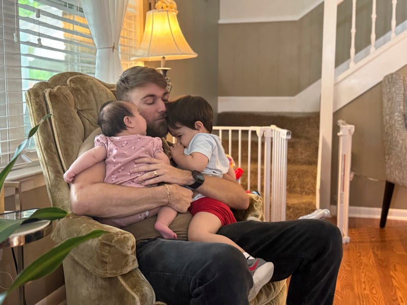 U.S. Marine Corps veteran Adrian Clouatre holds his 3-month-old daughter Lyn and his nearly two-year-old son Noah at their home in Baton Rouge, La. on Tuesday, June 17, 2025.