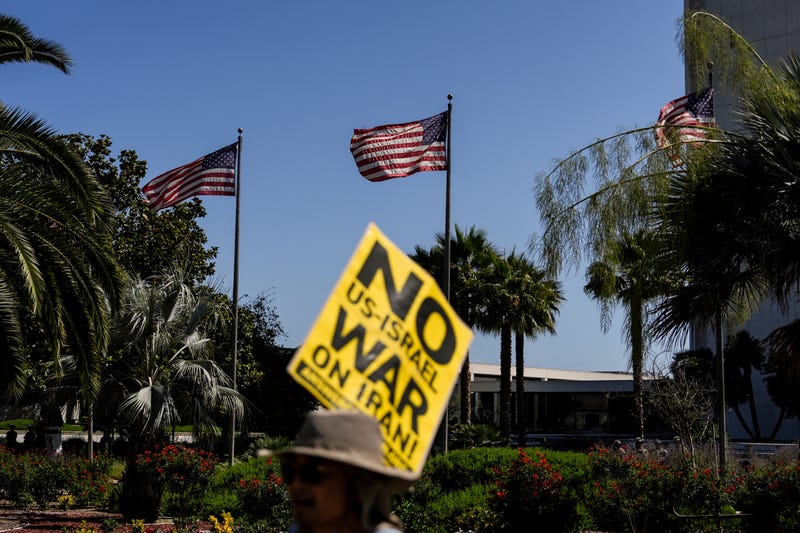 An anti-war demonstrator holds a sign outside the Wilshire Federal Building in Los Angeles Sunday, June 22, 2025, following U.S. airstrikes on Iran's nuclear facilities.