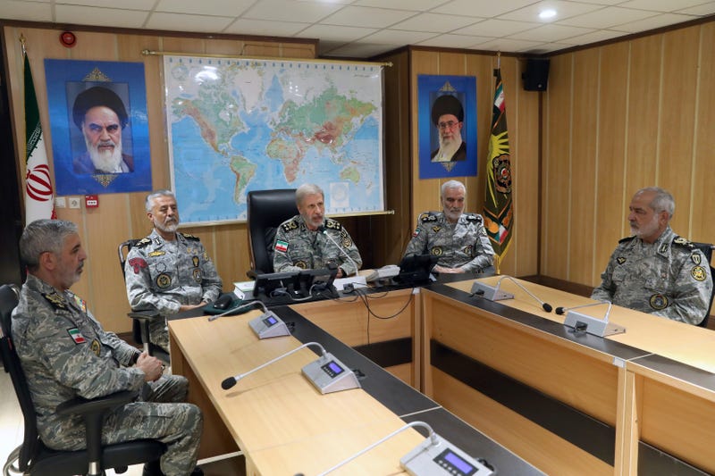 In this photo released on Monday, June 23, 2025, by Iranian army press service, Iran's army commander-in-chief Gen. Amir Hatami, center, accompanied by high ranked army commanders, speaks in a video call with top commanders of the army, in Zolfaghar central headquarters, Iran, as portraits of the late revolutionary founder Ayatollah Khomeini, left, and Supreme Leader Ayatollah Ali Khamenei hang on the wall.