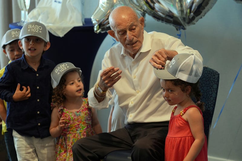 Harold Terens gifts customized hats to his great grandchildren during his 102 birthday party Saturday, July 26, 2025, in Delray Beach, Fla. 