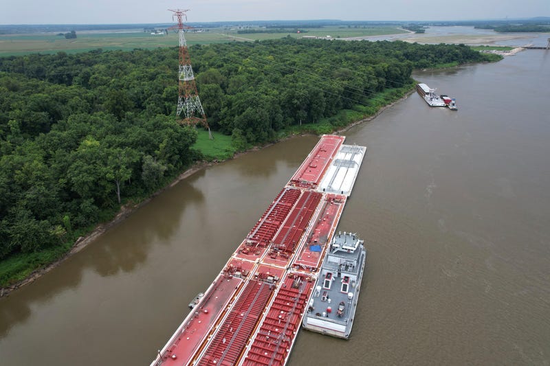 A blue tarp covers the wreckage of a helicopter after it clipped a power line spanning the Mississippi River and crashed onto a barge Thursday, Aug. 7, 2025, in East Alton, Ill.