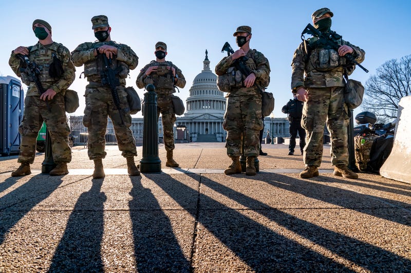 FILE - National Guard troops and the U.S. Capitol Police keep watch as heightened security remains in effect around the Capitol grounds in Washington, March 3, 2021.