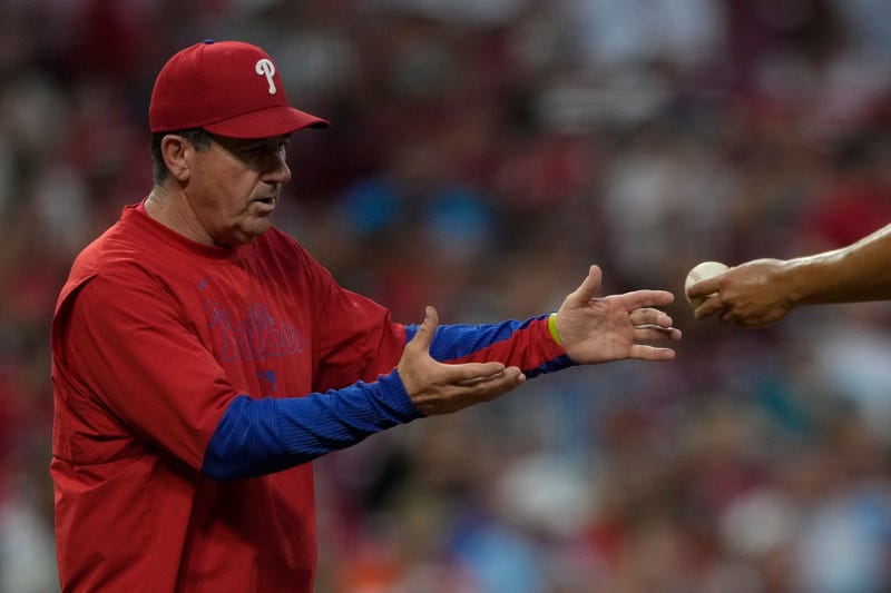 Philadelphia Phillies manager Rob Thomson, left, takes the ball from pitcher Ranger Suárez during a pitching change in the sixth inning of a baseball game against the Cincinnati Reds on Aug. 12, 2025, in Cincinnati.