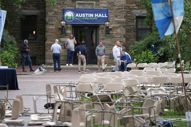 People use their phones in a mess of toppled chairs at the Villanova University campus, where an active shooter was reported on Aug. 21, 2025, in Villanova, Pa.