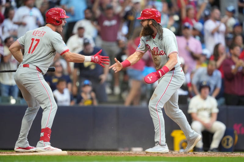  Brandon Marsh, right, celebrates with Max Kepler (17) after scoring on an RBI double hit by Harrison Bader during the eighth inning of a baseball game against the Milwaukee Brewers.