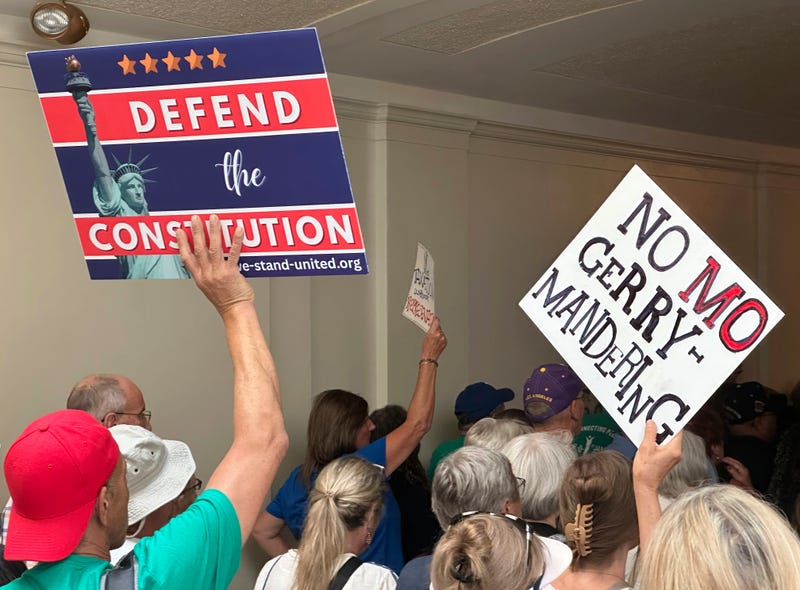 Opponents of a Republican plan to redraw Missouri's U.S. House districts march through a hallway outside the state Senate chamber in Jefferson City, Mo., Wednesday, Sept. 10, 2025.