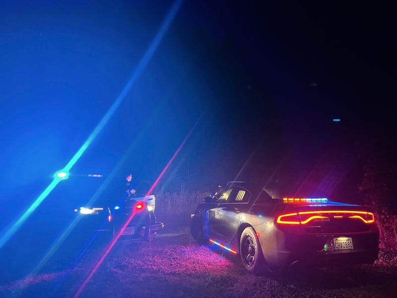 In this photo provided by the Thurston County Sheriff's Office, law enforcement personnel respond to a Wednesday evening, Sept. 17, 2025, helicopter crash near Joint Base Lewis-McChord in Washington state.