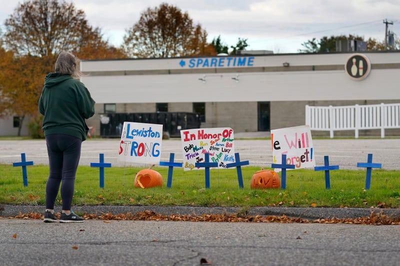FILE - A woman visits a makeshift memorial outside Sparetime Bowling Alley, the site of a mass shooting, Oct. 28, 2023, in Lewiston, Maine.