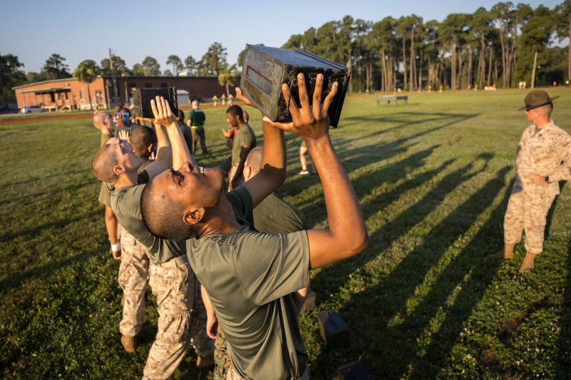 FILE - A group of male U.S. Marine Corps recruits train with weighted ammo cans during a physical training exercise at the Marine Corps Recruit Depot, June 28, 2023, in Parris Island, S.C.