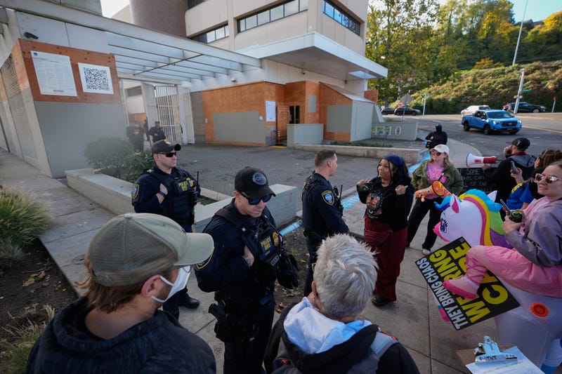 Law enforcement officers talk with protesters outside a United States Immigration and Customs Enforcement (ICE) facility in Portland, Ore., Monday, Oct. 20, 2025.