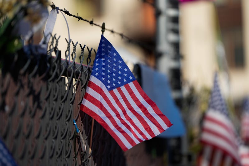 American flags line a fence across the street from a United States Immigration and Customs Enforcement (ICE) facility in Portland, Ore., Monday, Oct. 20, 2025.