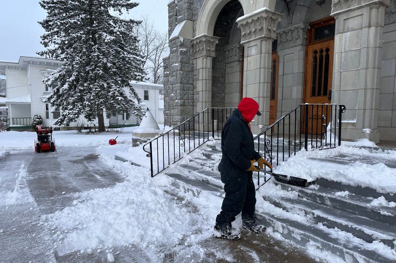 A man shovels snow outside a church in Lowville, N.Y., on Friday, Nov. 28, 2025