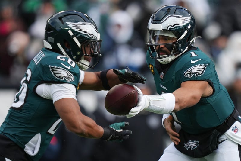 Philadelphia Eagles quarterback Jalen Hurts (1) hands off the ball to Philadelphia Eagles running back Saquon Barkley, left, during the first half of an NFL football game against the Las Vegas Raiders on Sunday, Dec. 14, 2025, in Philadelphia. 