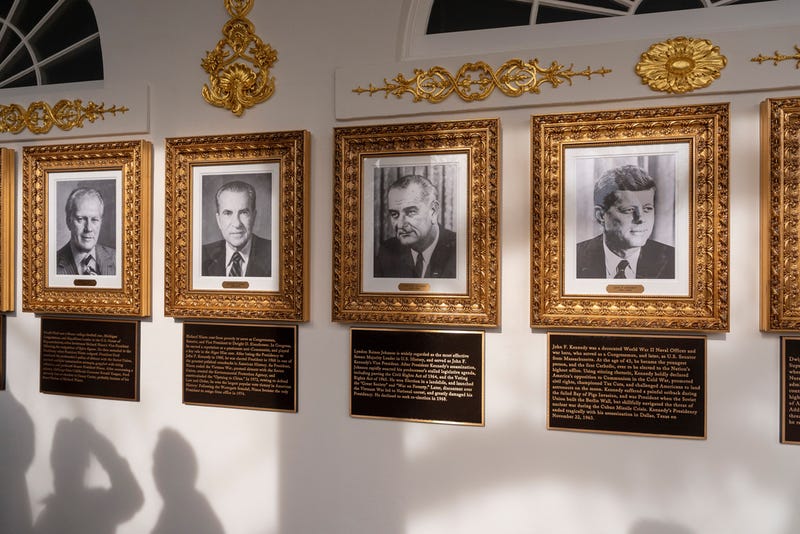 New plaques of explanatory text are seen beneath a framed portrait in the space for former President Joe Biden on the Presidential Walk of Fame on the Colonnade of the White House, Wednesday, Dec. 17, 2025, in Washington. 