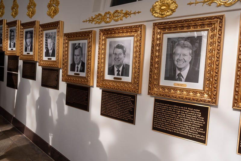 New plaques of explanatory text are seen beneath a framed portrait in the space for former President Joe Biden on the Presidential Walk of Fame on the Colonnade of the White House, Wednesday, Dec. 17, 2025, in Washington. 