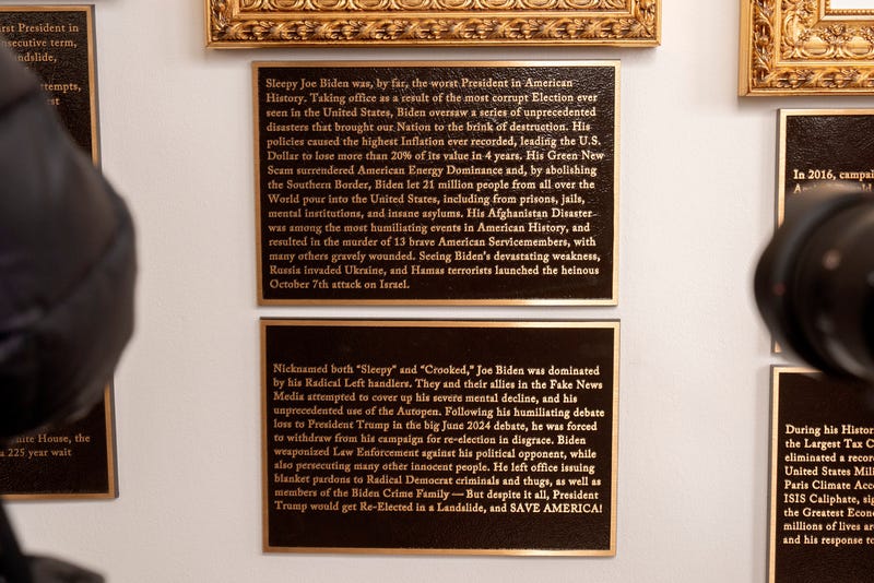 New plaques of explanatory text are seen beneath a framed portrait in the space for former President Joe Biden on the Presidential Walk of Fame on the Colonnade of the White House, Wednesday, Dec. 17, 2025, in Washington. 