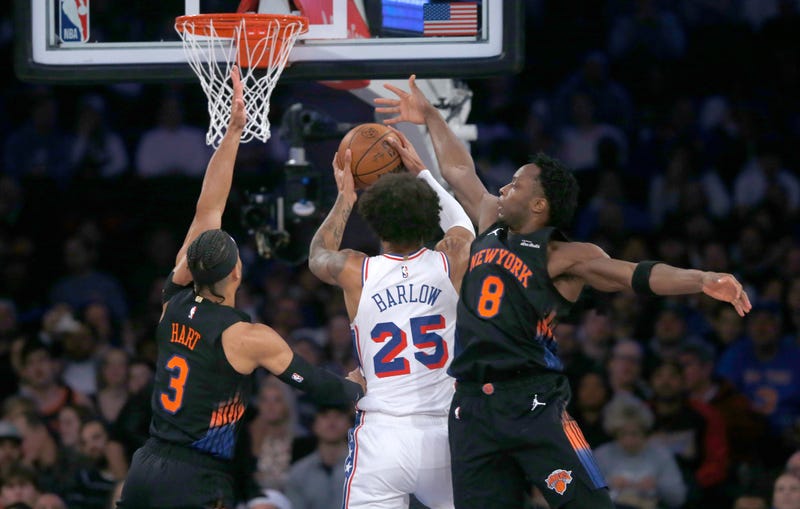 New York Knicks guard Josh Hart, left, and forward OG Anunoby, right, defend against Philadelphia 76ers forward Dominick Barlow, middle, during the first half of an NBA basketball game, Friday, Dec. 19, 2025, in New York.