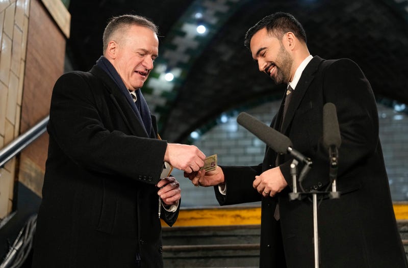 New York Mayor Zohran Mamdani, right, hands nine dollars to city clerk Michael McSweeney before signing a registry after being sworn in as mayor, Thursday, Jan. 1, 2026, in New York