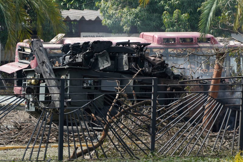 A destroyed armored vehicle sits at La Carlota airport in Caracas, Venezuela, Saturday, Jan. 3, 2026, after explosions were reported at the site.